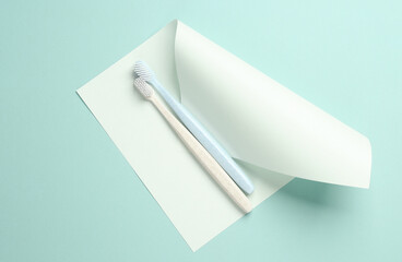 Toothbrushes with sheet of paper on a blue background. Creative layout