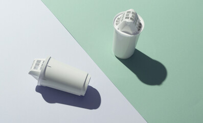 Cartridge filters for water filtration on pastel background.