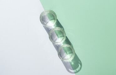 Glasses of water with reflection and shadow on pastel background. Minimalism. Top view