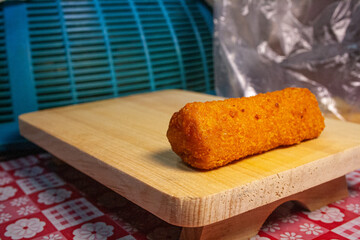 Risoles or risol, a popular Indonesian snack, essentially a type of fried pastry filled with meat or vegetables. Risoles on a wooden boardv