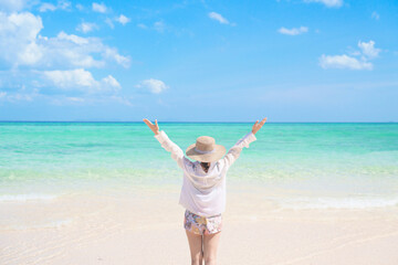 Happy Woman tourist with hat relaxing and enjoying on beach, young solo traveller looking beautiful sea view on tropical island. Southeast Asia destination, summer Travel, vacation and holiday