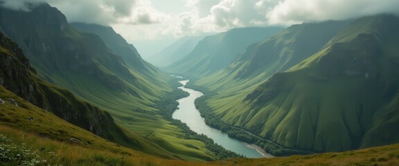 Fototapeta premium Serpentine river flowing through lush green mountain valley under soft, cloudy sky