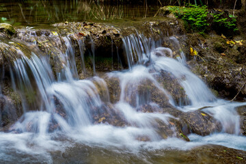 Cascading water flows over rocks in a peaceful natural setting