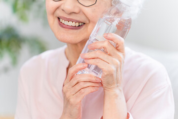 ペットボトルの水を飲むシニア女性