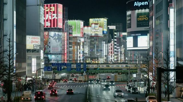 Shinjuku, Tokyo, Japan &ndash; February 2025: Night View of Urban Cityscape with Buildings,  Crowd of people at zebra crossing near Kabukicho downtown area. Buildings, train and street traffic.