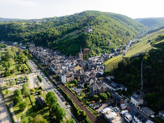 Aerial drone view of Bacharach, historic German town in the UNESCO Upper Middle Rhine Valley. Features Stahleck Castle, Wernerkapelle ruins, St. Peter's Church, vineyards, and the Rhine River.