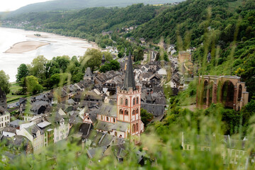 Viewpoint over Bacharach, Germany, highlighting St. Peter's Church and the Wernerkapelle ruins, with the Rhine River and town rooftops. A scenic glimpse into the UNESCO Upper Middle Rhine Valley.