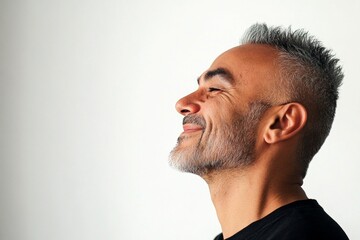 Obraz premium A radiant and poised man in a professional portrait. Visual idea of style for aging men. Pure white solid background. Modish men's edgy haircut - midlife arabian man with short hair.