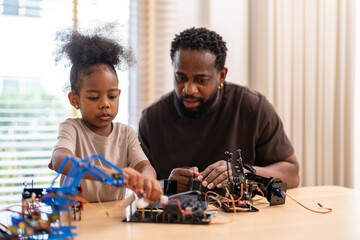 African father and daughter playing with stem robot kit, stem toys for kids fun learning and creativity at home, coding and building robots educational play activities, engineering skills development © Art_Photo
