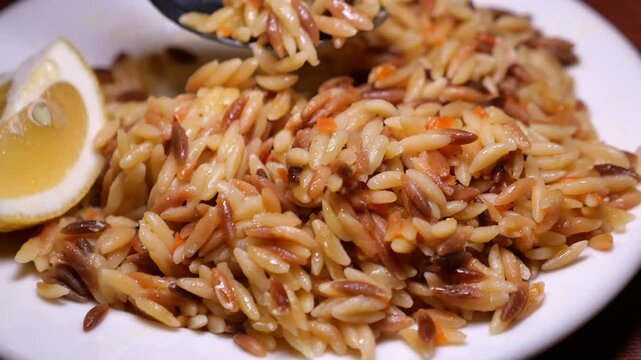 Delicious orzo dish with lemon wedges served fresh