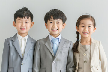 Group of young boys and girls in business suits, smiling confidently in a corporate themed setting. Their outfits and expressions reflect a professional, polished look.