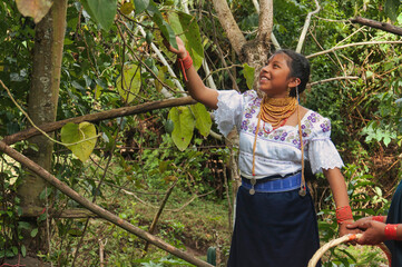 Indigenous girl harvesting tropical fruit in lush rainforest