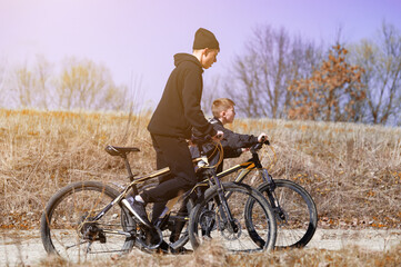 Fototapeta premium Two boys enjoy a sunny bike ride through a field, enjoying the fresh air and the beautiful scenery.