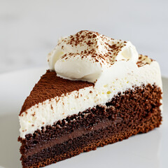 Rich and moist chocolate cake with glossy ganache topping, served on a ceramic plate with a fork beside it.