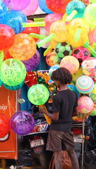 an indian boy selling balloons in the street