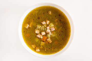 A hearty bowl of aromatic green soup filled with tender meat and colorful veggies