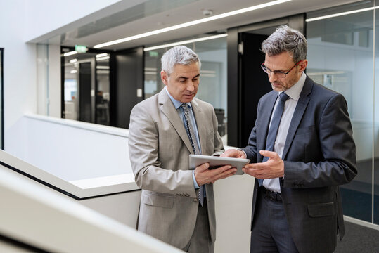 Business professionals discussing strategy in an office with a tablet
