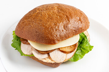 Savory sandwich on artisan bread, filled with greens, meats, and creamy cheese, tempts passersby