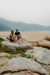 Couple relaxing on rocky beach landscape with mountain views
