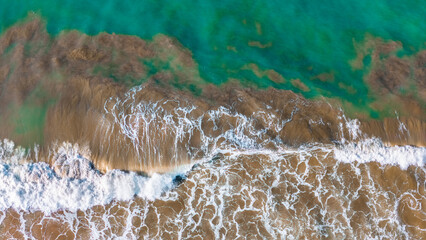 Aerial View of Turquoise Sea Waves Gently Crashing on the Coastline Ideal for Relaxation Content