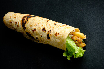 Savory wrap showcases tender chicken, vibrant lettuce, and golden fries, perfect for a quick meal
