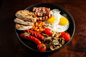 Savor a bright breakfast of sunny-side-up eggs, crispy bacon, sausages, and fresh tomatoes