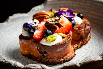 Colorful brunch features sweet bread topped with berries, nuts, and edible flowers