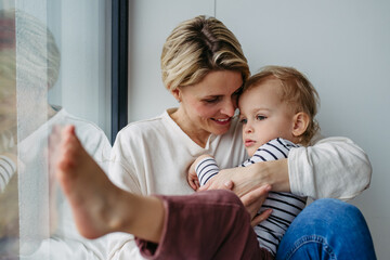 Beautiful mother hugging little son,