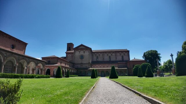 Ferrara, Italy - May 17, 2025: Wide angle view of San Cristoforo church in Charterhouse of Ferrara cloister with columns framing the main building. Summer day in Ferrara, Italy
