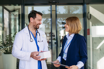 Fototapeta na wymiar Female medical sales representative presenting medication to doctor