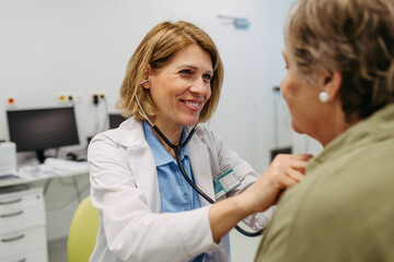 Geriatrician listening to senior patient's heartbeat.