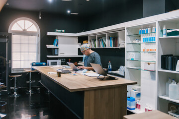 Veterinarian working on laptop in modern clinic pharmacy
