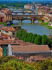 From a bird’s-eye view, Ponte Vecchio stretches gracefully across the Arno River, its centuries-old arches and vibrant storefronts embodying the timeless charm of Florence.