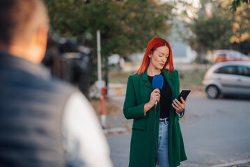 Female journalist reporting live news with microphone and smartphone