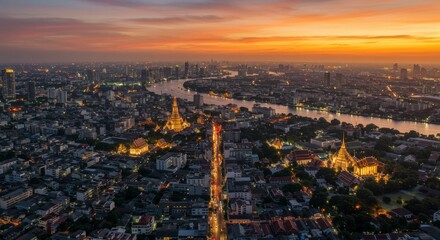 Obraz premium Panoramic sunset view of a city, river, and illuminated temples
