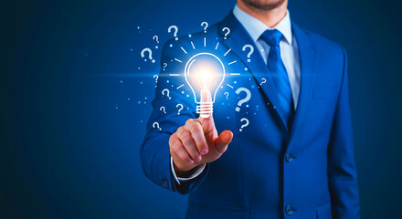 Businessman touching a light bulb surrounded by question marks on a blue gradient background
