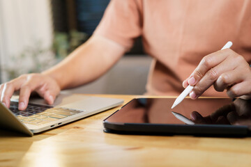 Unrecognizable woman working in working room at home, woman stylus pen writing on the digital...