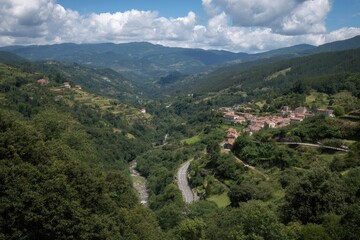 Fototapeta premium Lush Green Valley with Hidden Rural Village