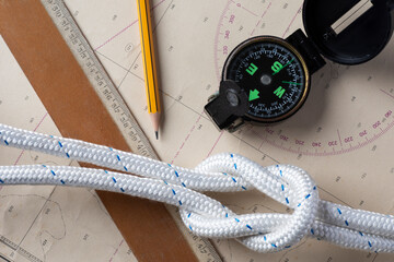 Strumenti di navigazione su mappa nautica con bussola e corda