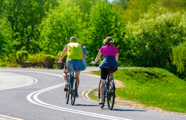 Fototapeta premium Cyclists ride on the bike path in the city Park 