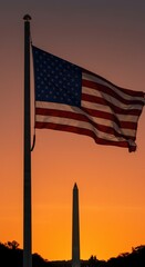 Naklejka premium American flag silhouetted against sunset sky and monument