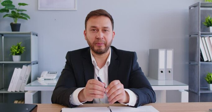 Portrait of a positive businessman working on online video call or conference in office, talking via camera with internet, focusing on communication and connection in a professional setting.