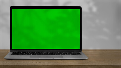 Tablet with green screen outdoors, trees swaying in the background.