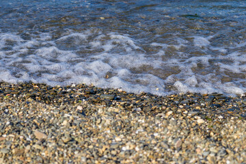 view of small foaming waves on the coastline in Izmir Park in Turkey