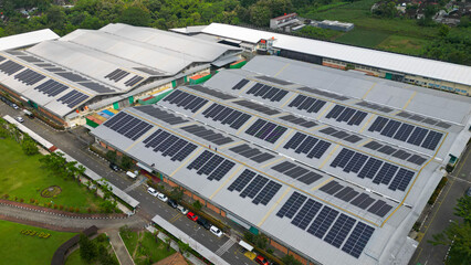 Rows of solar panels installed on the rooftop of a factory, capturing sunlight efficiently as part of a clean energy solution in an industrial landscape.