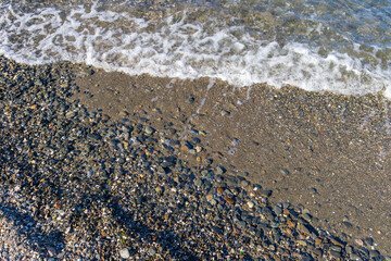 view of small foaming waves on the coastline in Izmir Park in Turkey