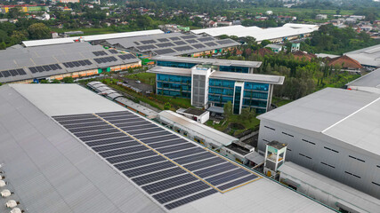 Rows of solar panels installed on the rooftop of a factory, capturing sunlight efficiently as part of a clean energy solution in an industrial landscape.
