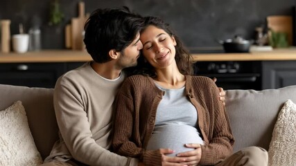 Happy pregnant woman and her husband showing affection on a sofa - Powered by Adobe
