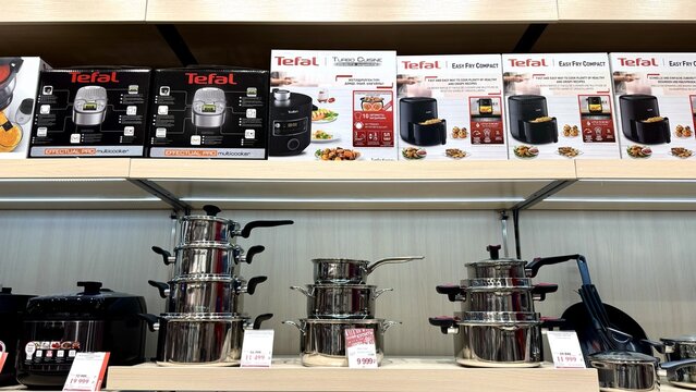 Tefal cookware and appliance store display featuring multiple pressure cookers and food processors arranged on modern retail shelves..