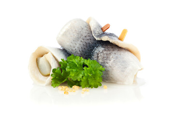 German Rollmops - kipper wrapped around pickled cucumber, garnished with parsley and mustard seeds, on white background